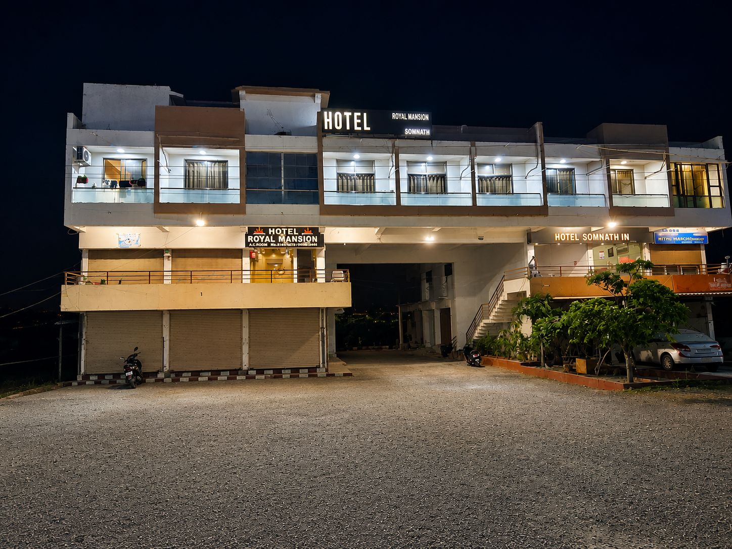 Um hotel com várias varandas, entrada coberta e estacionamento.