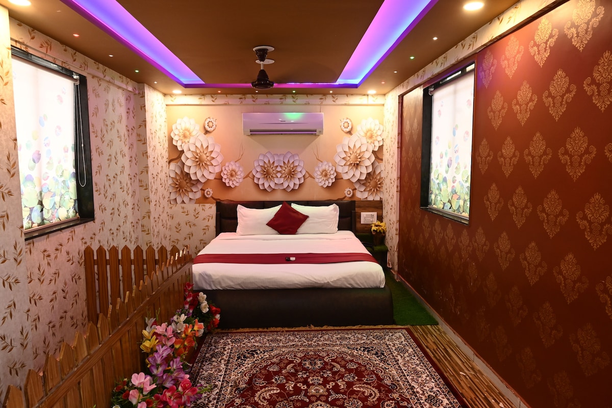 A room with a bed, floral wallpaper, a patterned rug, and a ceiling fan.