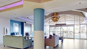 A spacious lobby with a large central column, seating areas, and a modern ceiling design. - Cozy studio condo with direct ocean view in amazing Daytona Beach (Daytona Beach)