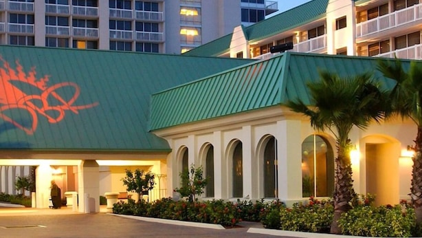 A hotel with a green roof, multiple balconies, and a large building in the background. - Cozy studio condo with direct ocean view in amazing Daytona Beach (Daytona Beach)