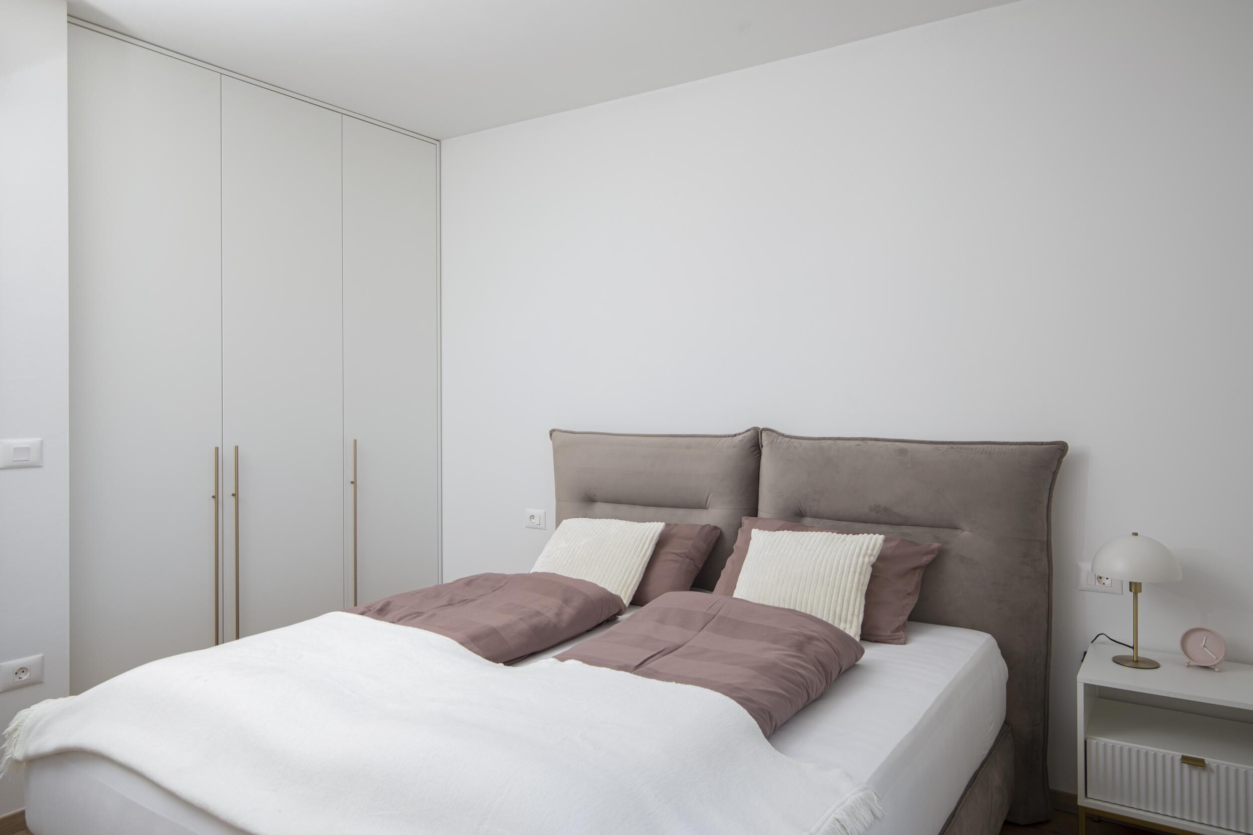 Ein Schlafzimmer mit Bett, Nachttisch und Kleiderschrank.