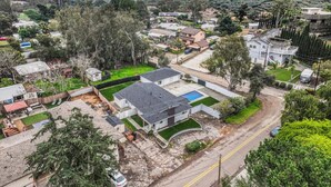 An aerial view of a residential area with houses, a swimming pool, and a mountain in the background. - Spacious 5BR Retreat-Sleeps 10+ (El Cajon)