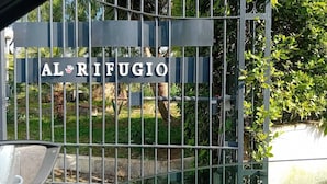 A metal gate with the inscription "AL RIFUGIO" and a palm tree in the background. - AL RIFUGIO (Montecorvino Pugliano)