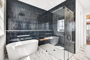 Une salle de bain moderne avec une baignoire sur pieds, une douche à parois de verre et un grand miroir.