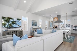 Relax in this spacious room with a large sofa, flat-screen TV, and kitchen area.