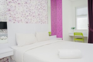 A bedroom with a bed, a desk, a chair, and a TV. - Homey Studio Apartment with Pool View at Springwood Residence (Tangerang)