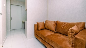 Ein braunes Sofa mit Kissen in einem Raum mit weißen Wänden und einer weißen Tür.