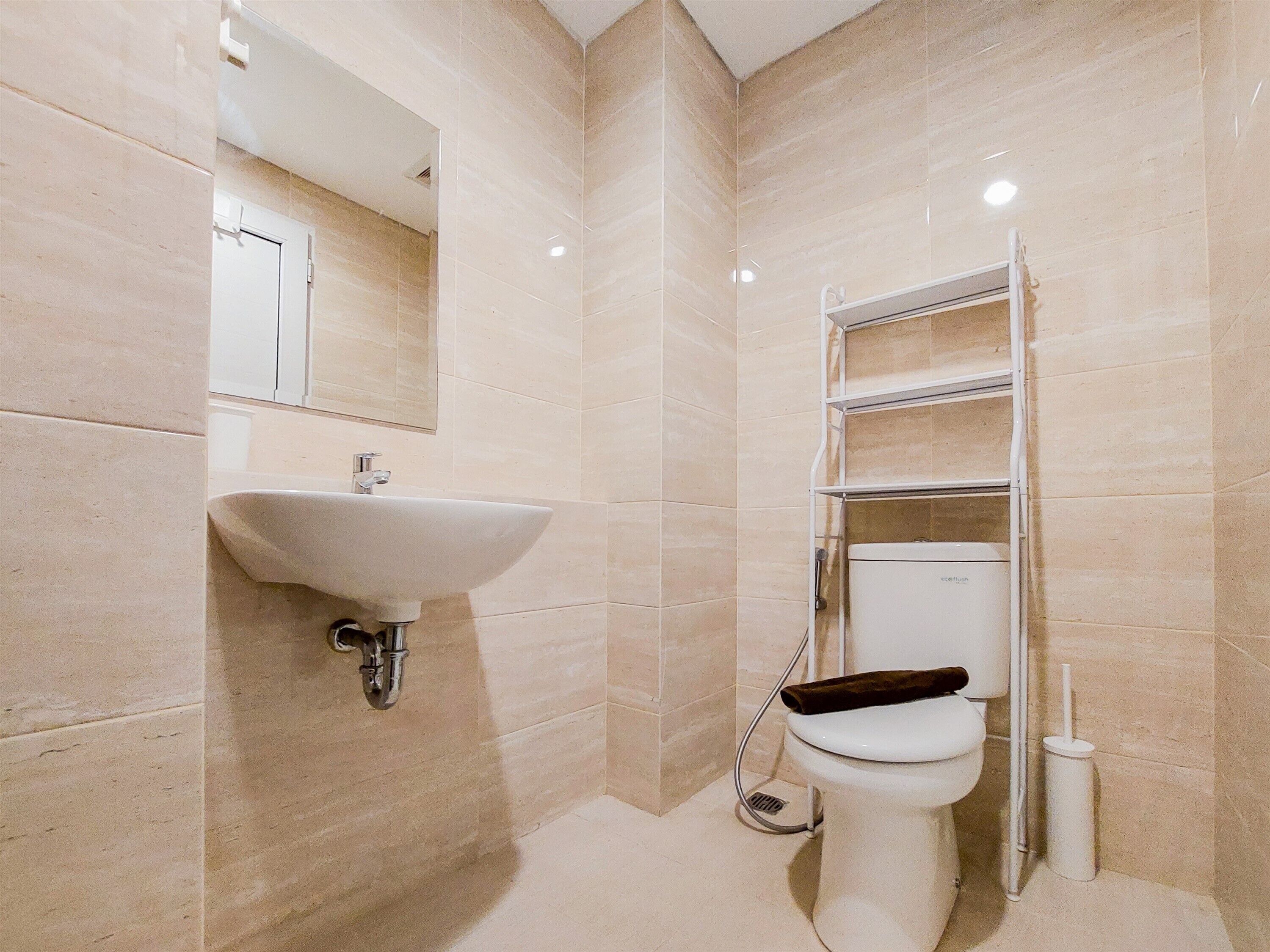 Une salle de bain équipée d’un lavabo, de toilettes et d’une étagère.