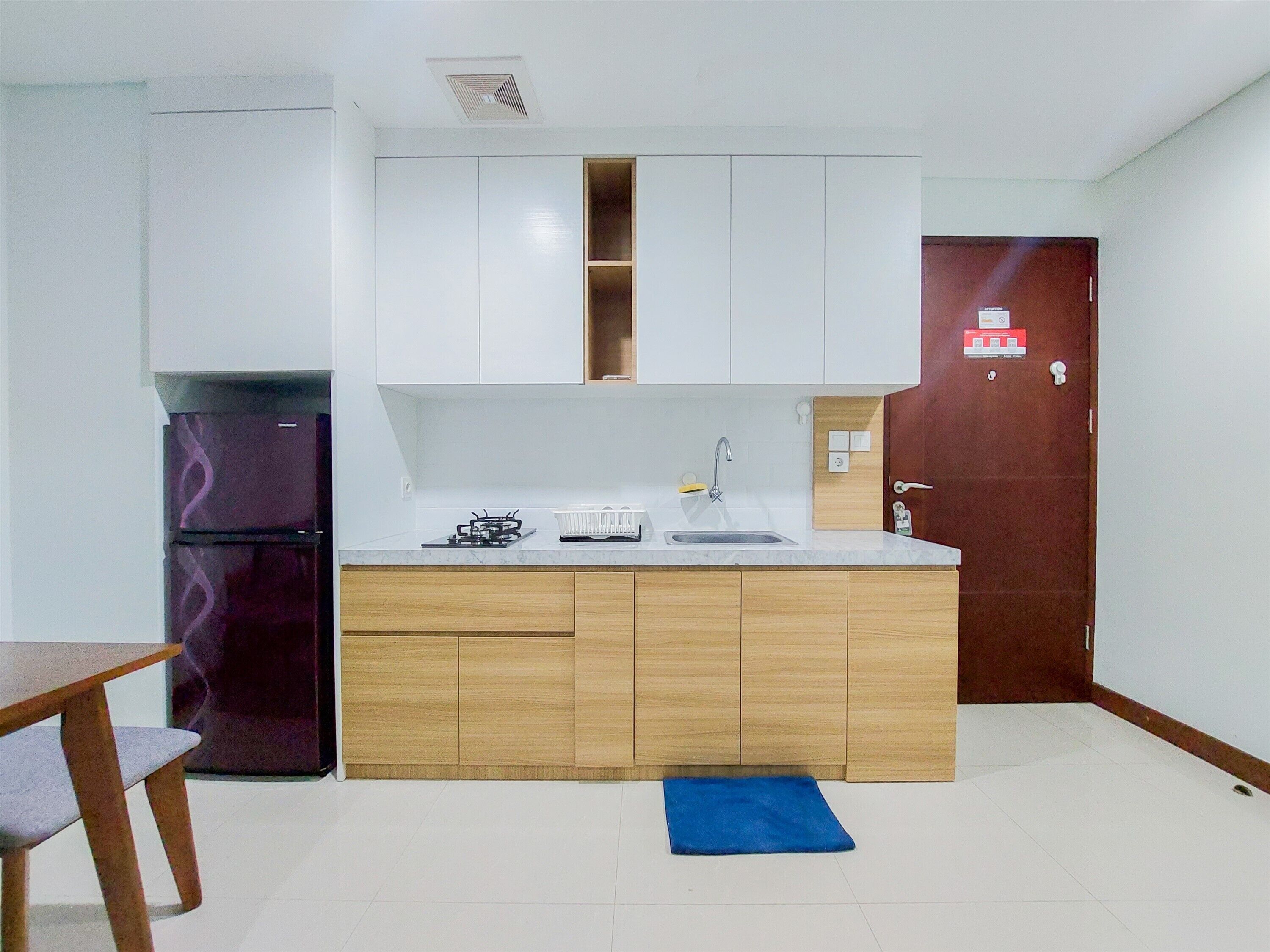 A compact kitchen with white cabinets, a built-in stove, and a sink.