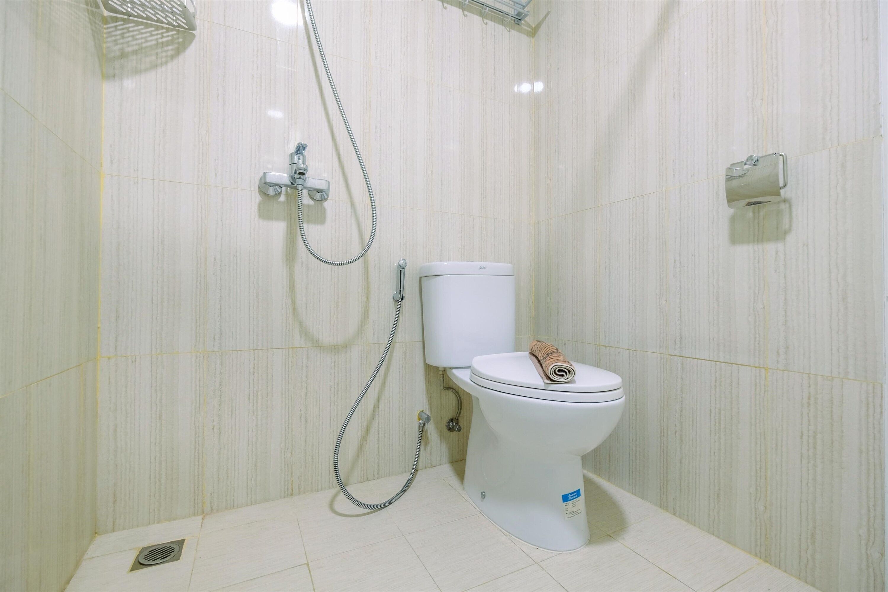Kylpyhuone, jossa on wc, suihku ja käsienkuivaaja.