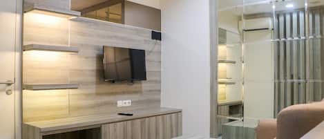 Ein modernes Wohnzimmer mit integriertem Fernseher, Holzregalen und einer Glastrennwand.