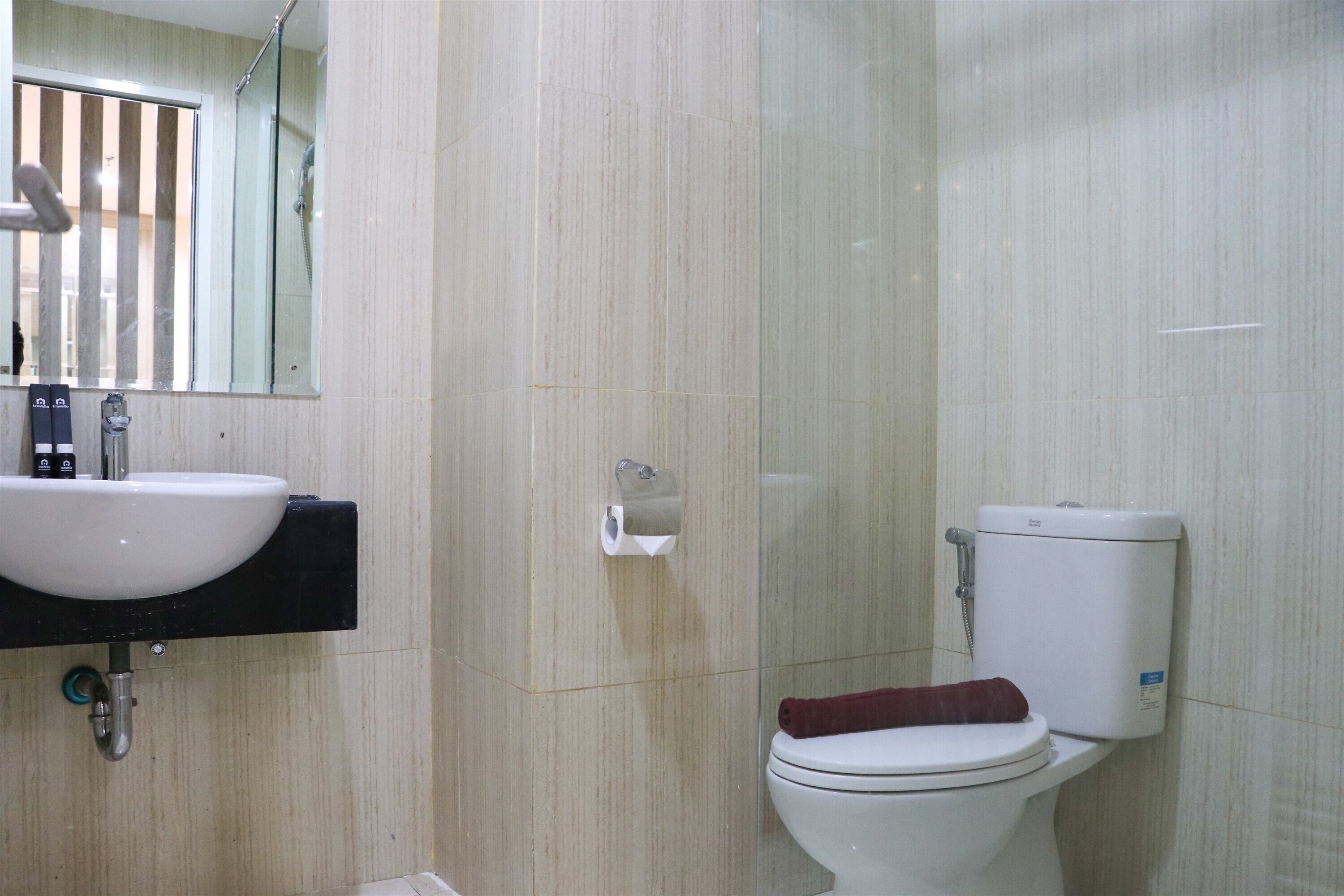 Un baño con lavamanos, inodoro y ducha blancos.