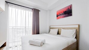 Ein ordentlich bezogenes Bett mit weißen Leinentüchern und zwei aufgerollten Handtüchern, ein Stadtbildgemälde an der Wand und ein Fenster mit durchsichtigen Vorhängen.