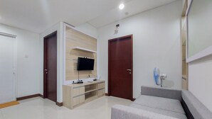 A modern living room with a grey sofa, wooden entertainment unit, and a TV.