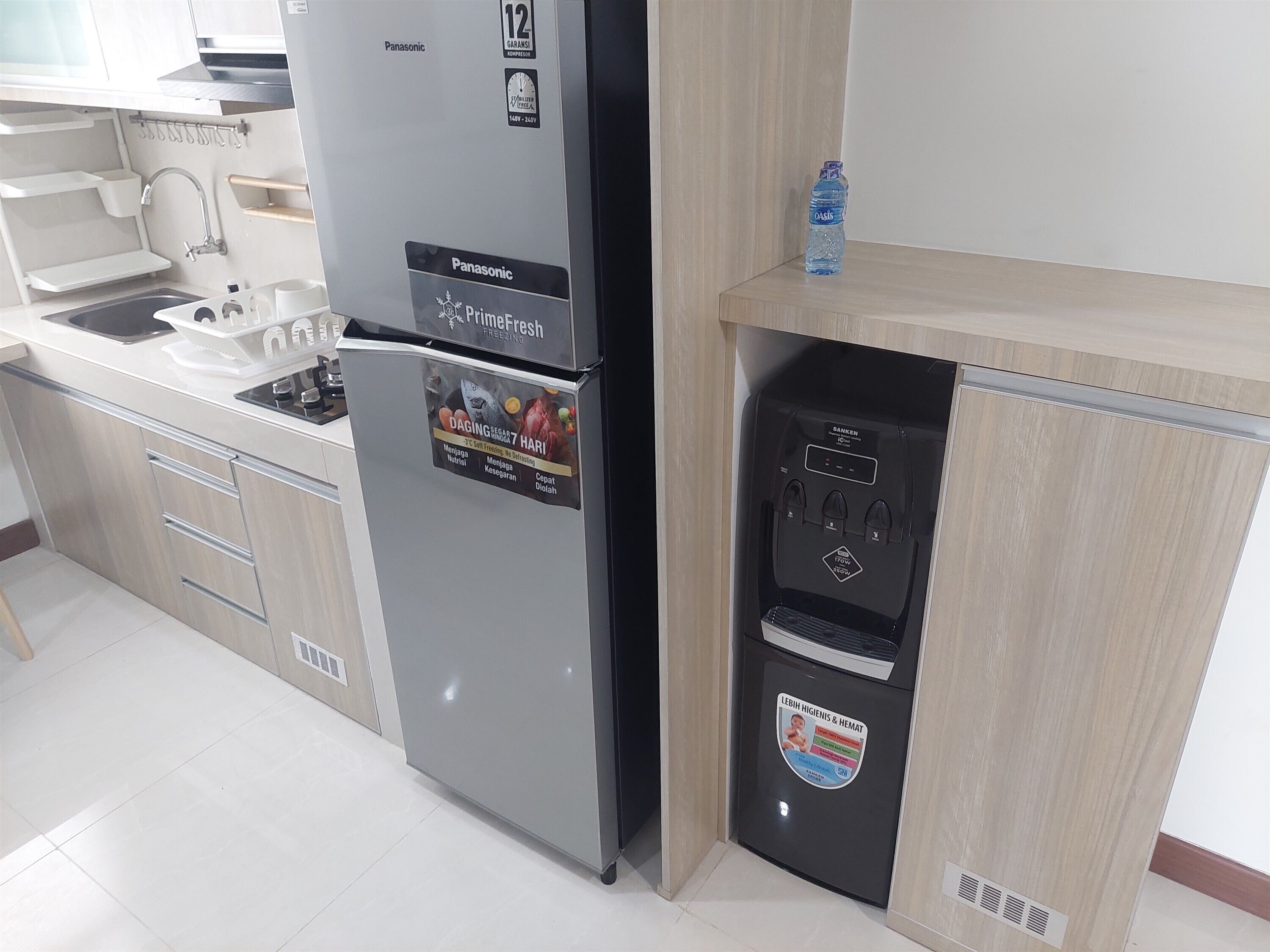 A kitchen with a Panasonic refrigerator, a water dispenser, and a sink.