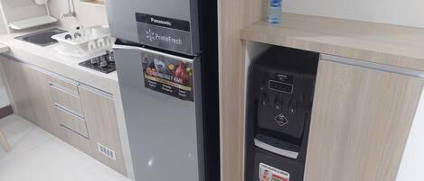 A kitchen with a Panasonic refrigerator, a water dispenser, and a sink.
