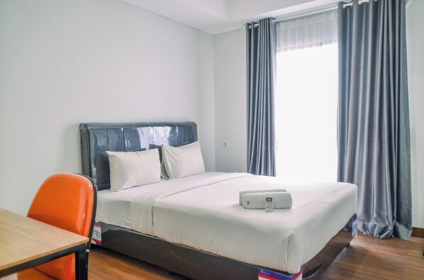 Hotellihuone, jossa on sänky, työpöytä ja tuoli.