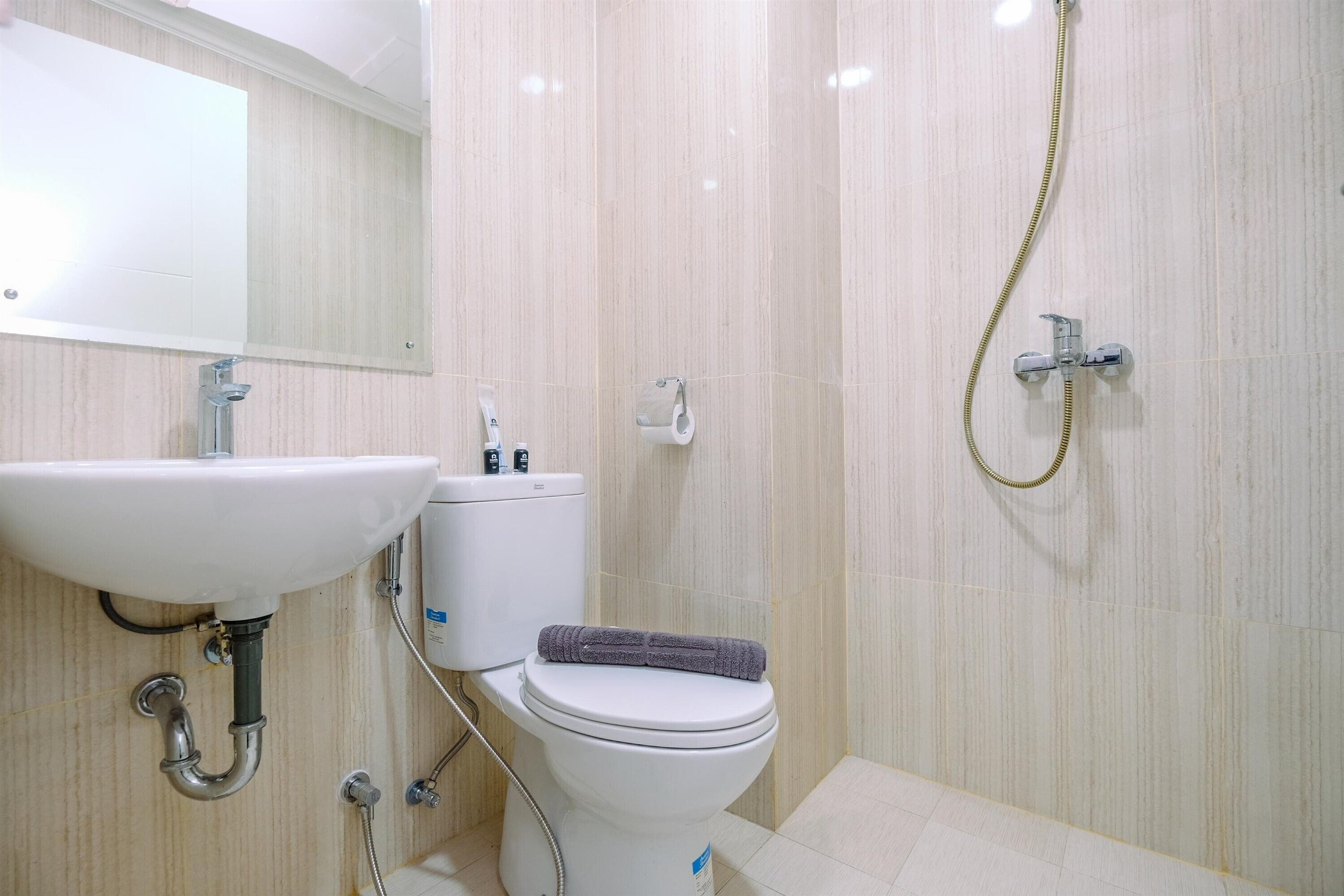 Et badeværelse med vask, toilet og brusebad.