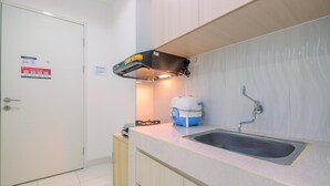 A kitchen with a sink, a water dispenser, and a cabinet.