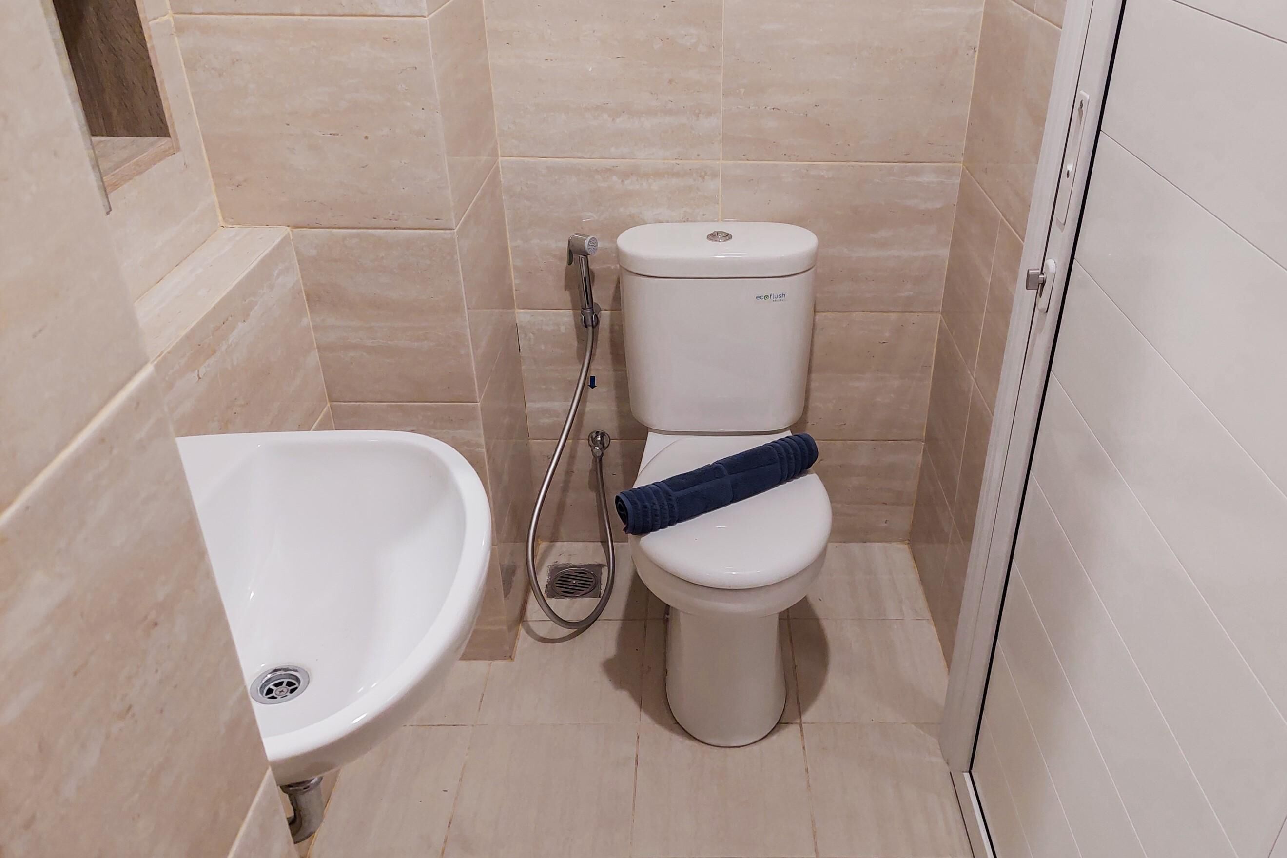 Et badeværelse med bidét, toilet og brusebad.