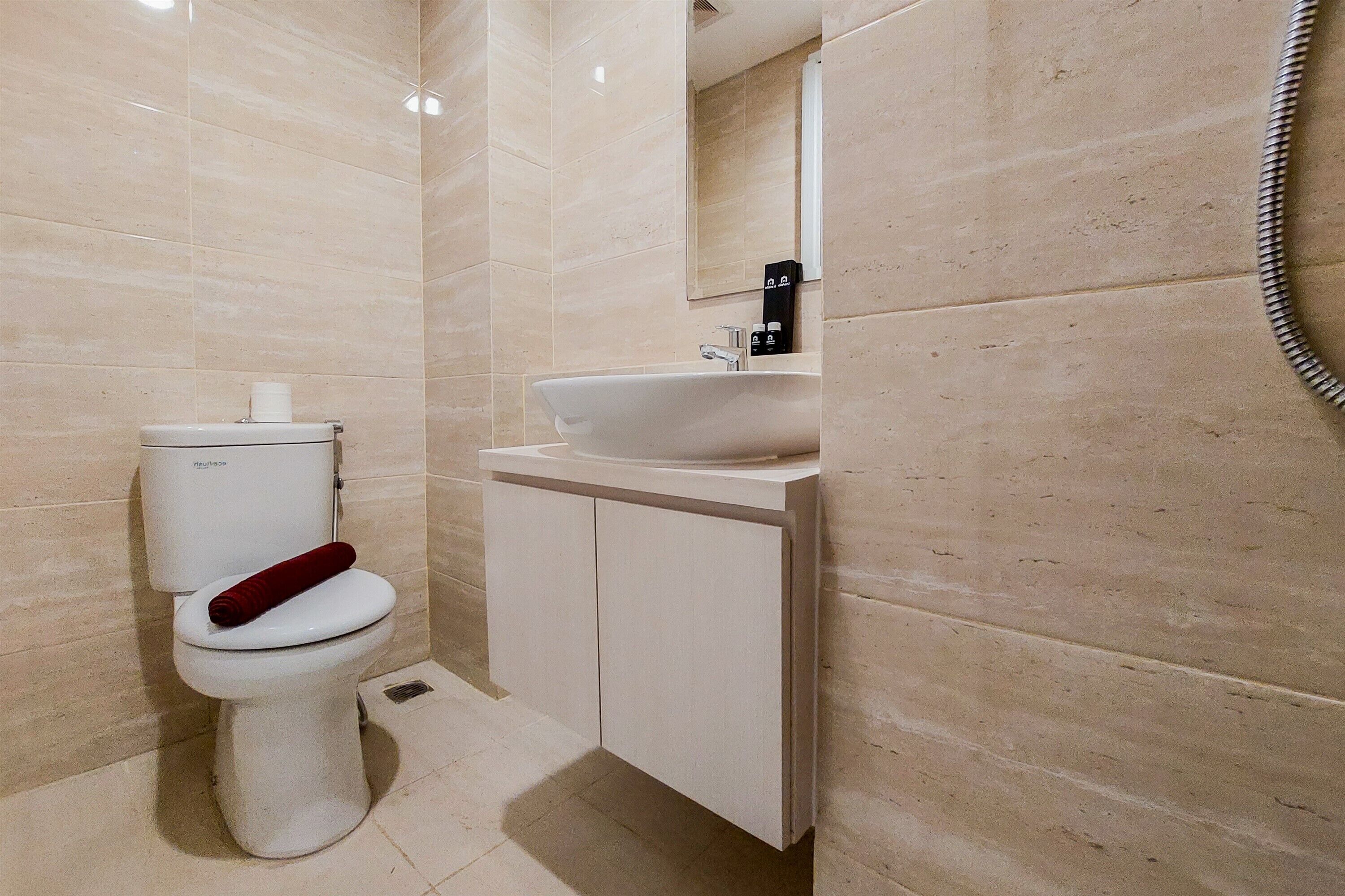 A modern bathroom with a toilet, sink, and mirror.