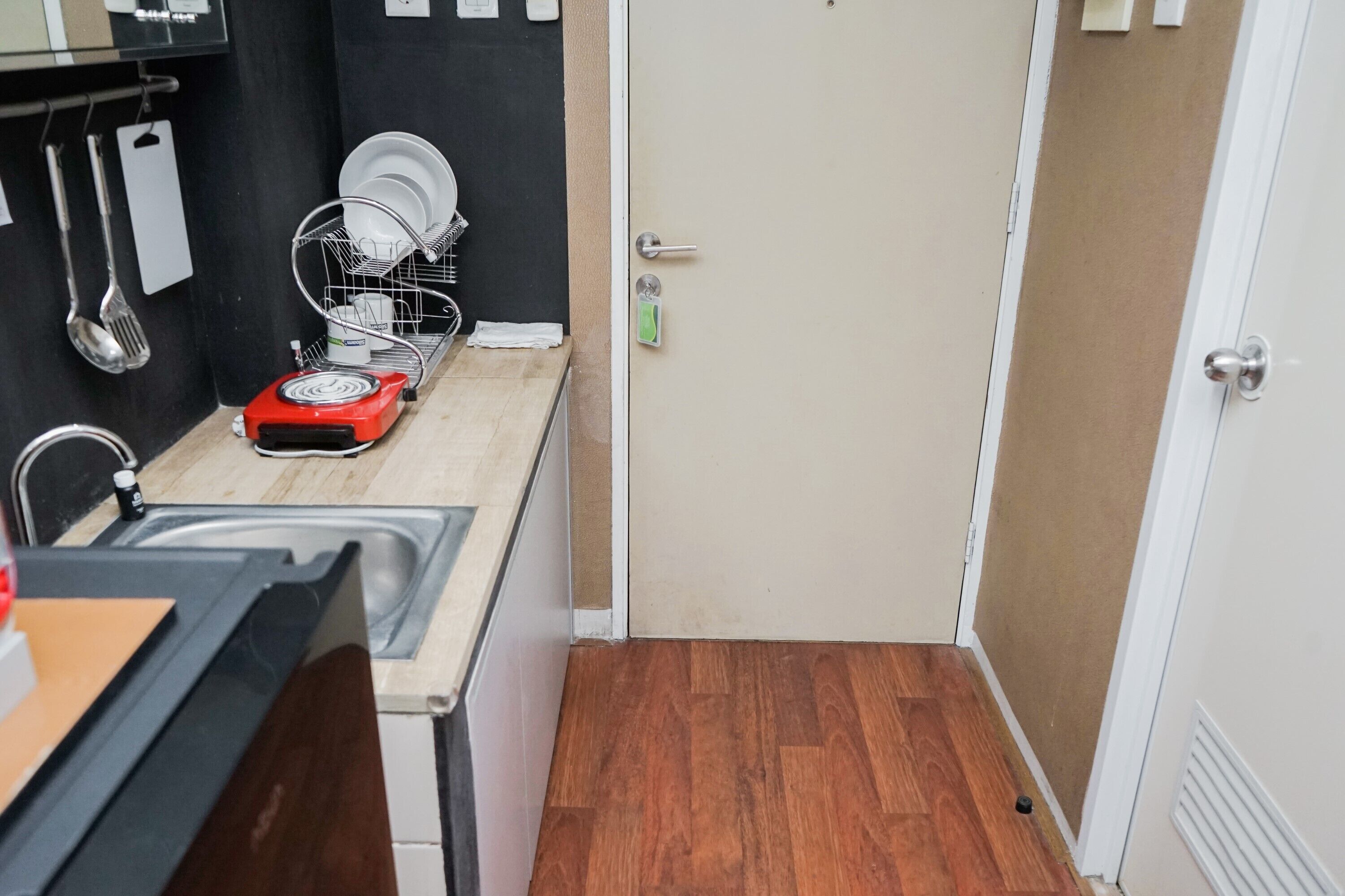 A compact kitchen with a sink, a dish rack, and a small countertop.