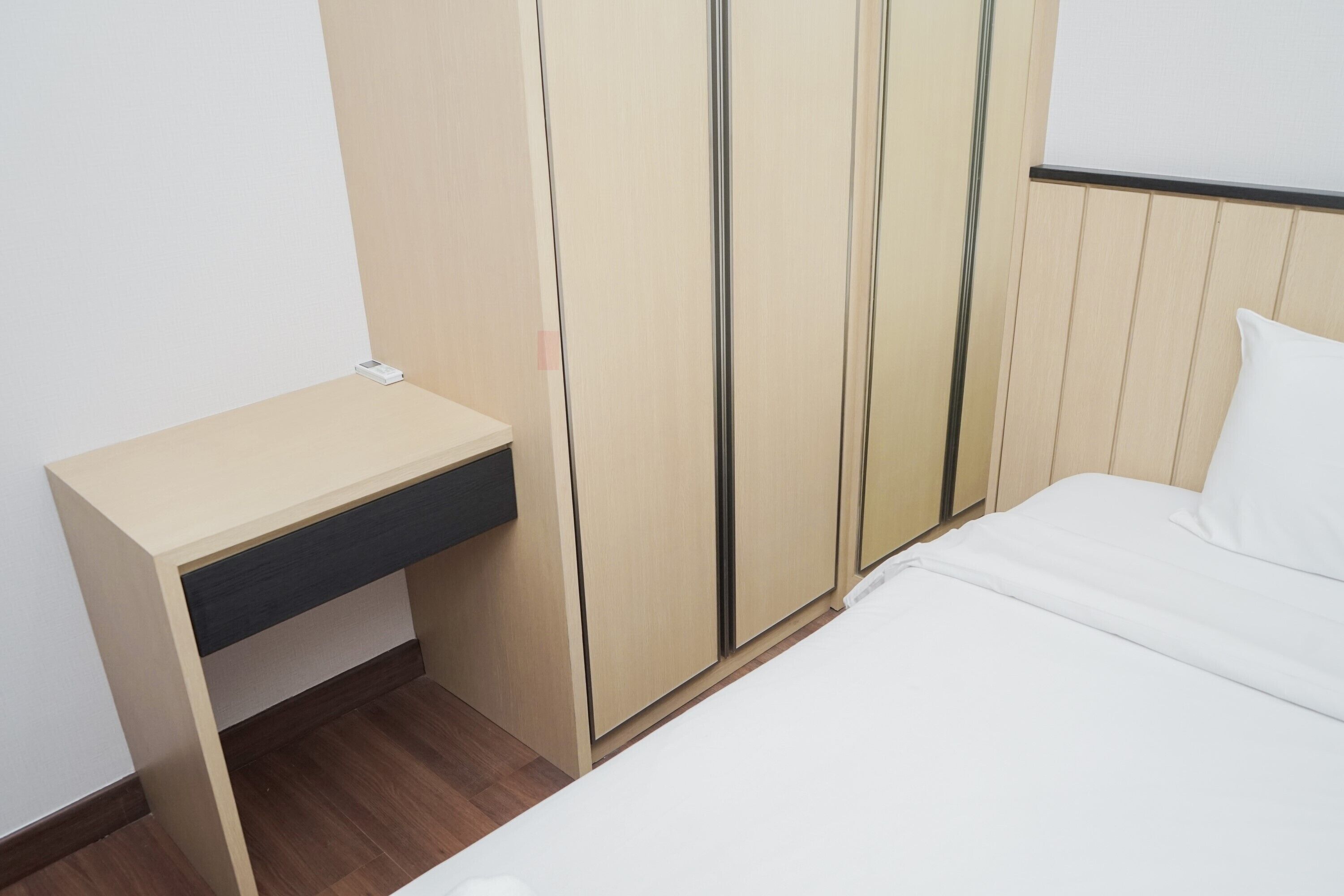 Ein Schlafzimmer mit einem Bett, einem Holztisch und einem Kleiderschrank.