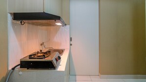 Eine kleine Küche mit Gasherd, Dunstabzugshaube und Spüle.
