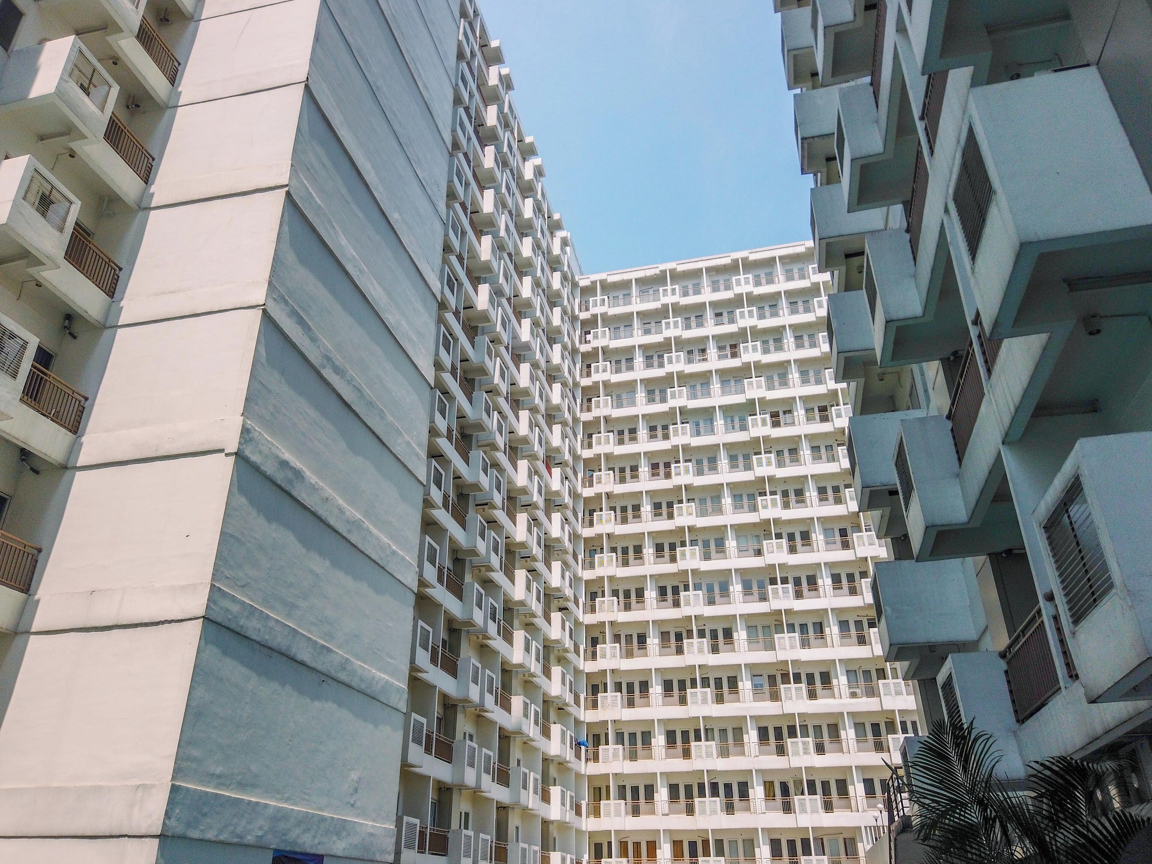 A high-rise residential building with multiple balconies and air conditioning units.