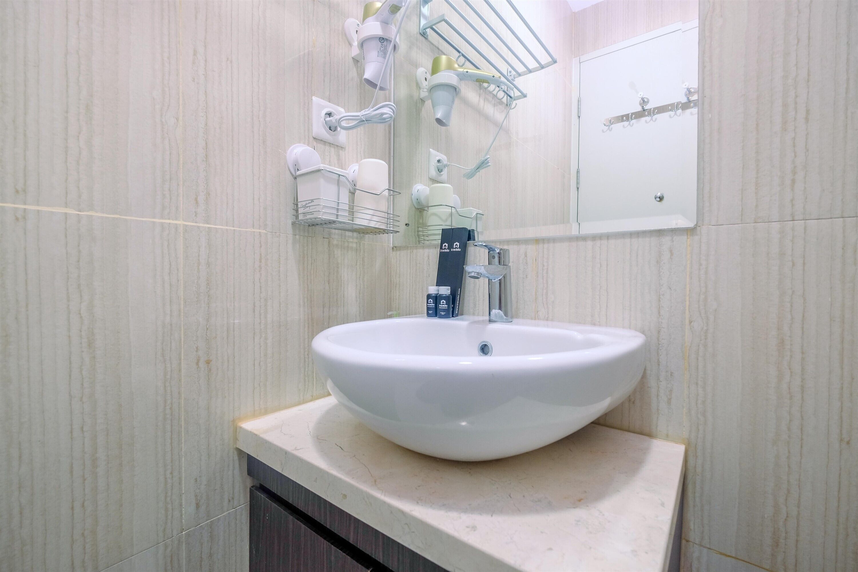 Une salle de bain avec un lavabo blanc, un miroir et un porte-serviettes.