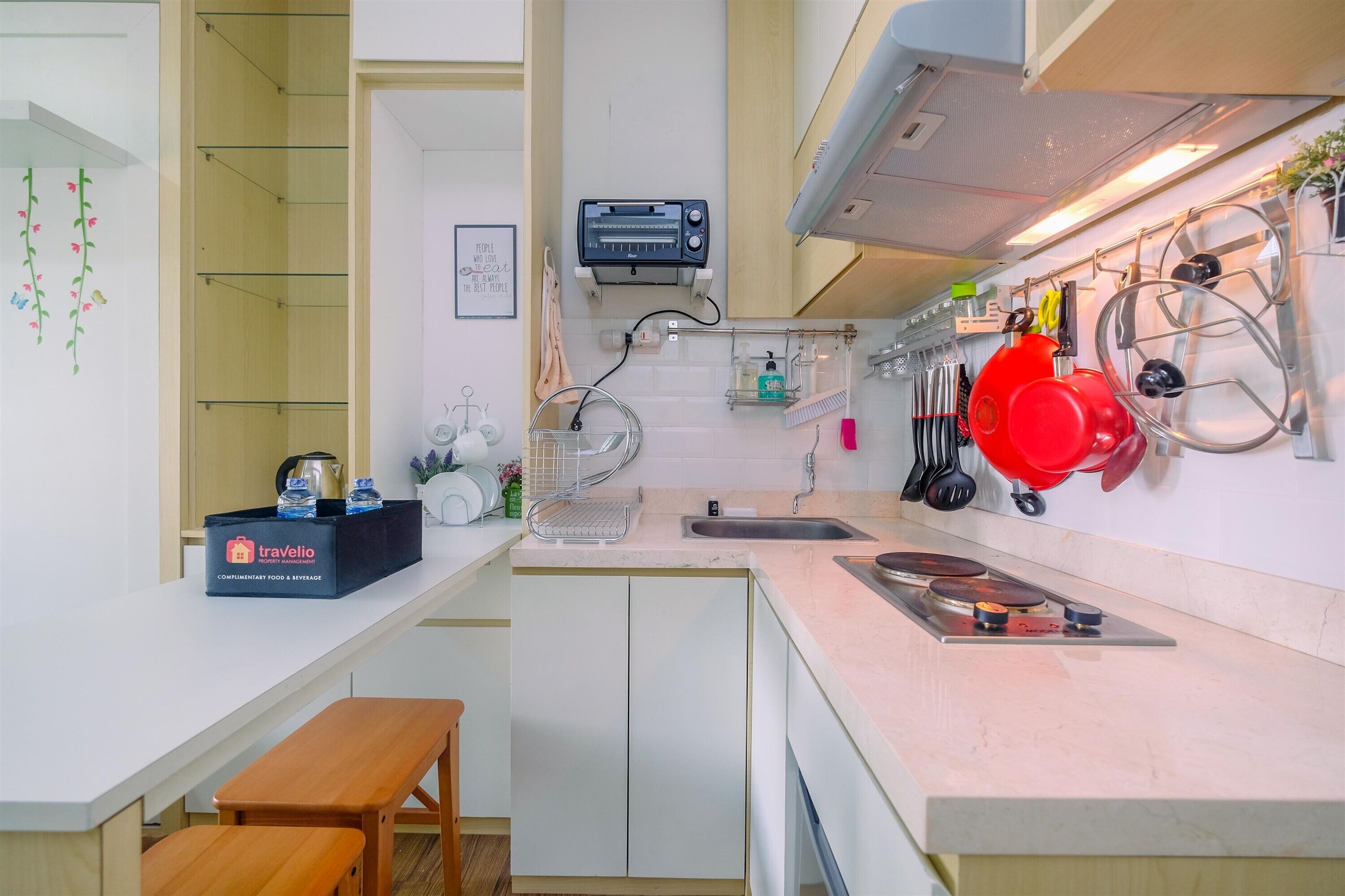 A compact kitchen with a countertop, a sink, a toaster, and a bench.