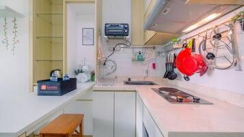 A compact kitchen with a countertop, a sink, a toaster, and a bench.