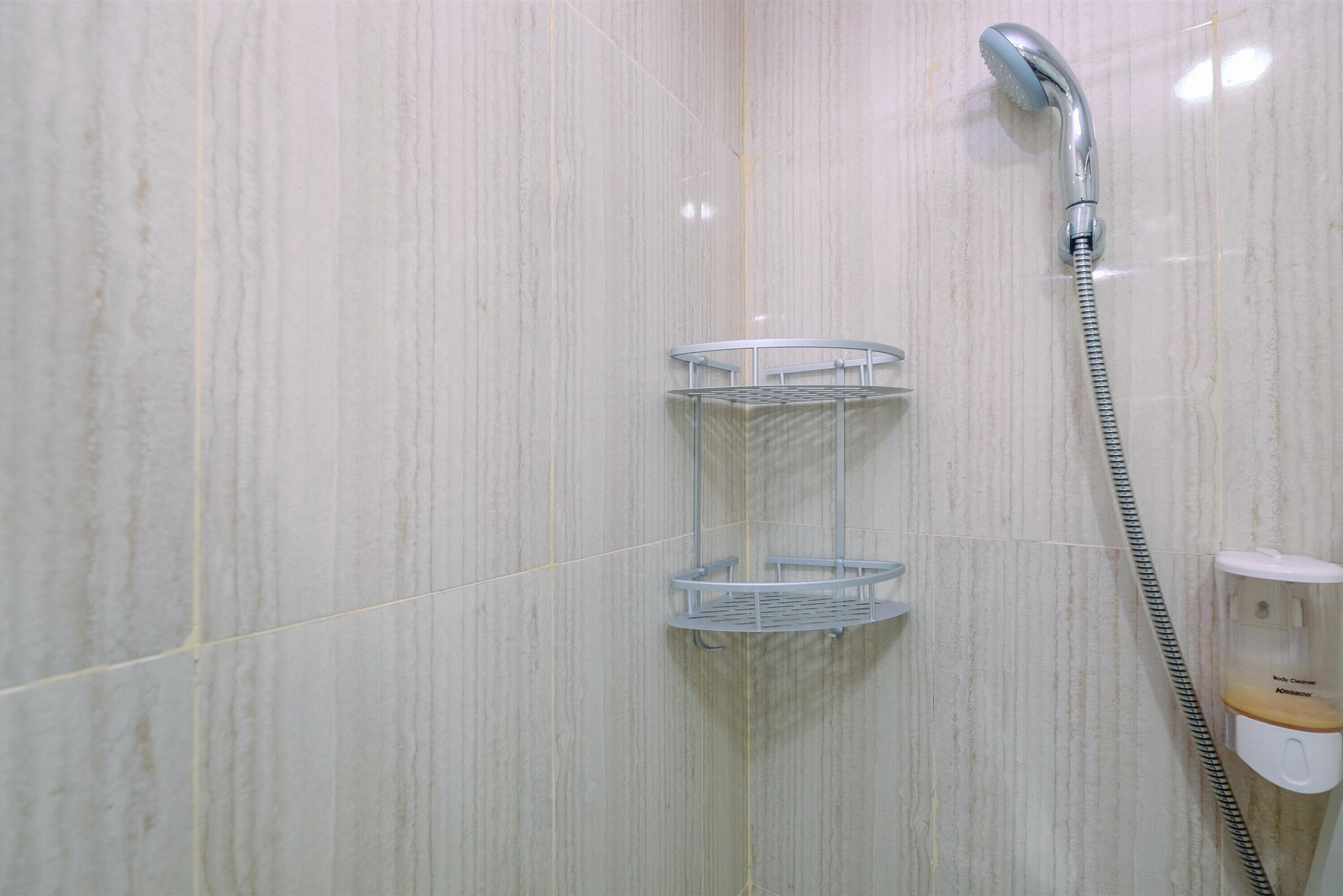 Une salle de bain équipée d’une douche, d’un sèche-mains et d’un distributeur de savon.