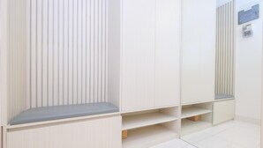 Een kamer met een ingebouwde bank, een spiegeldreven kast en een betegelde vloer.