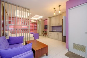 Relax in a spacious living area with a sofa, TV, and kitchenette.