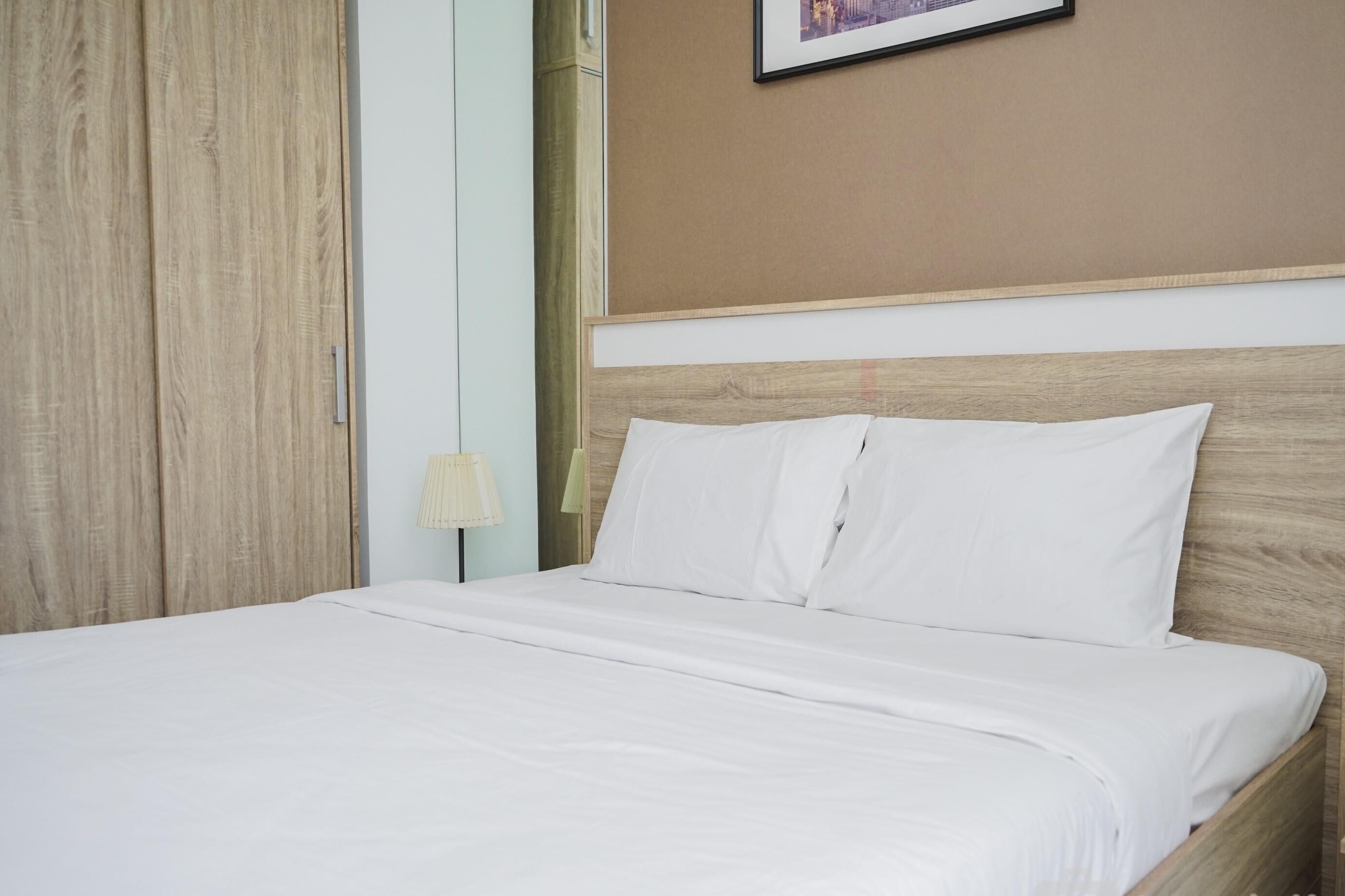 Un lit bien fait, avec du linge de lit blanc, dans une chambre d'hôtel.