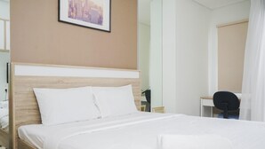 A neatly made bed with white linens in a hotel room. - Fully Furnished with Cozy Design Studio Springwood Residence Tangerang Apartment (Tangerang)