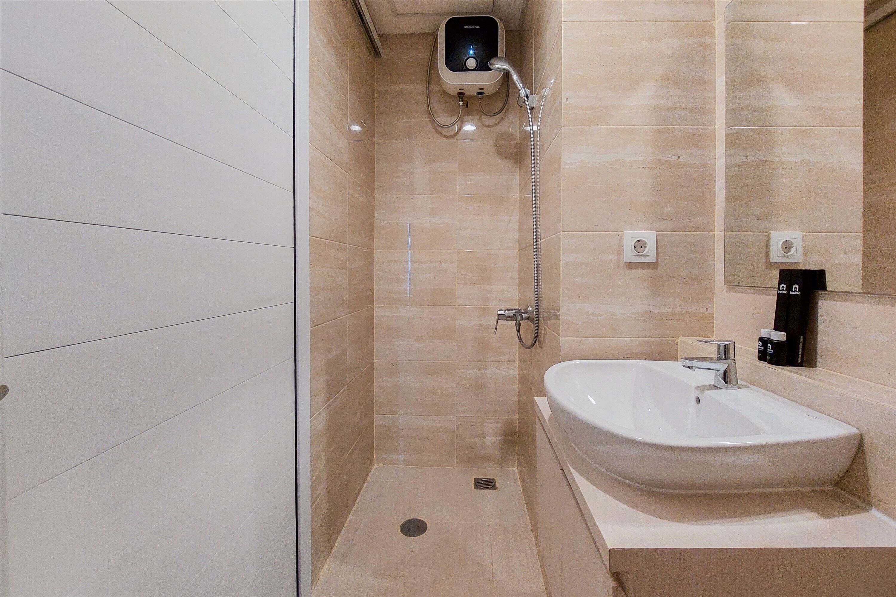 A modern bathroom with a shower, a sink, and a mirror.