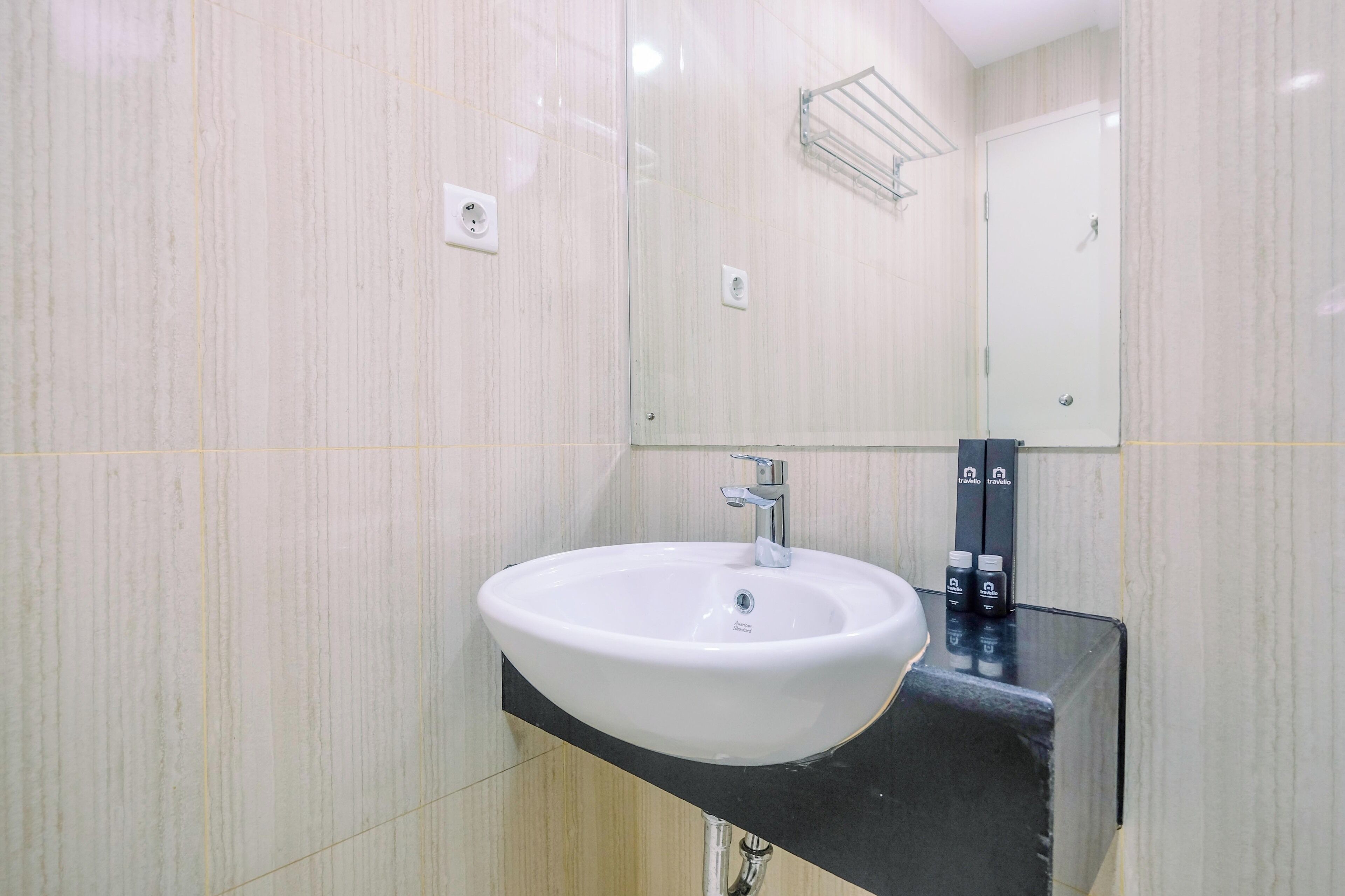 A modern bathroom with a white sink, black countertop, and a mirror above the sink.