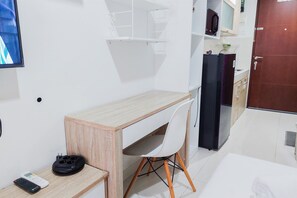 Cozy retreat with a compact kitchenette, flat-screen TV, and comfortable bed.