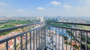 Ein Balkon mit Blick auf die Stadt, einschließlich Gebäude und Straßen.