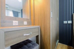 Een moderne badkamer met een houten wastafelmeubel, een spiegel en een handdoekhouder.