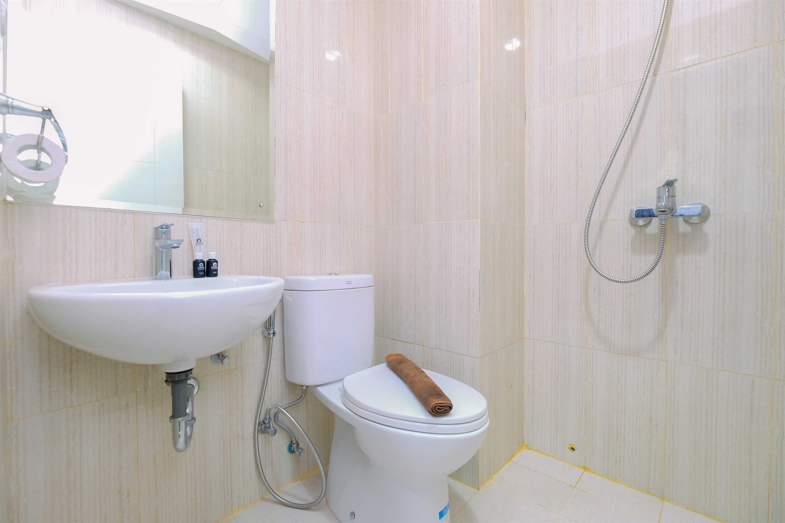 Une salle de bain avec des toilettes, un lavabo et une douche.