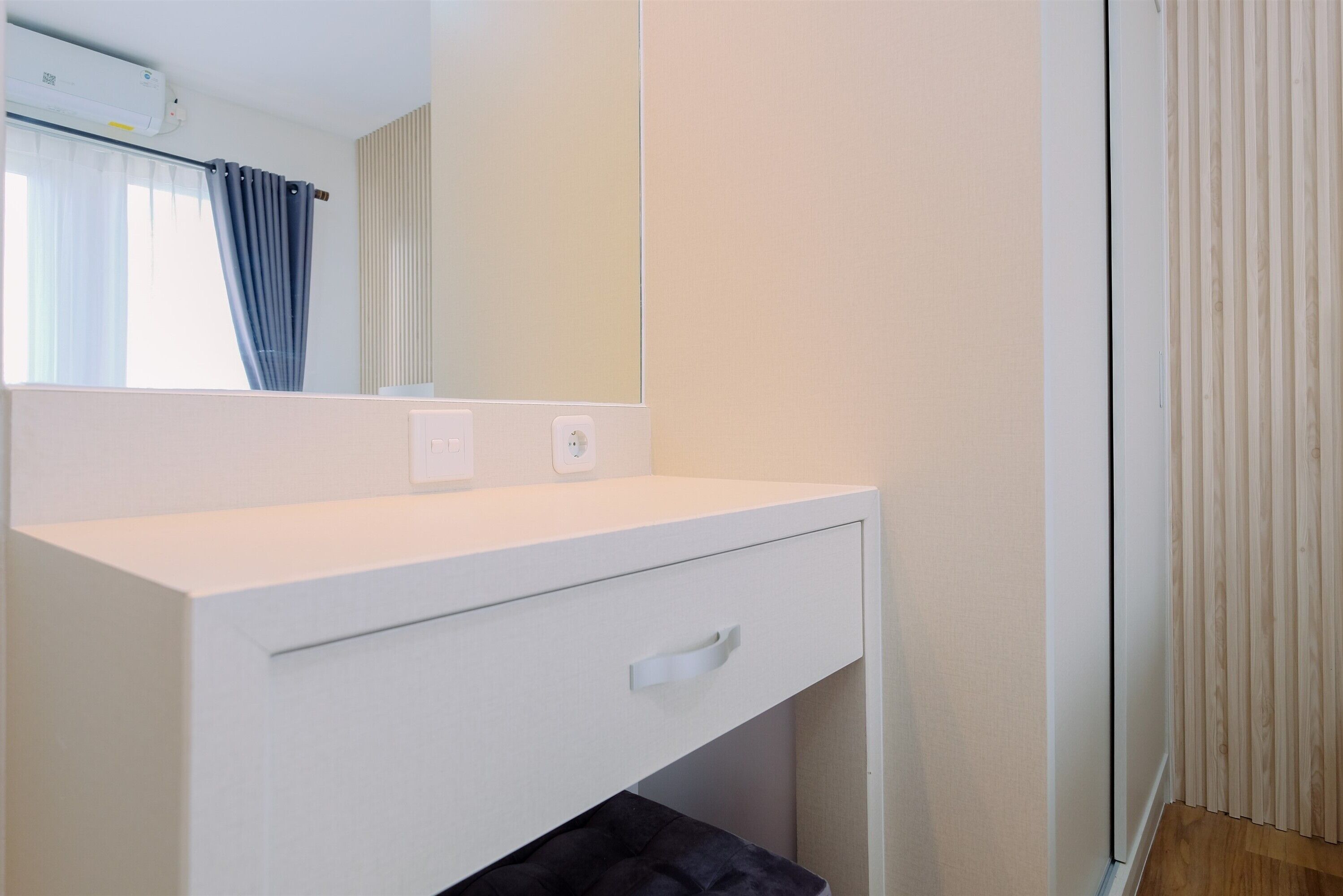 A modern bathroom with a white vanity, a mirror, and a towel rack.