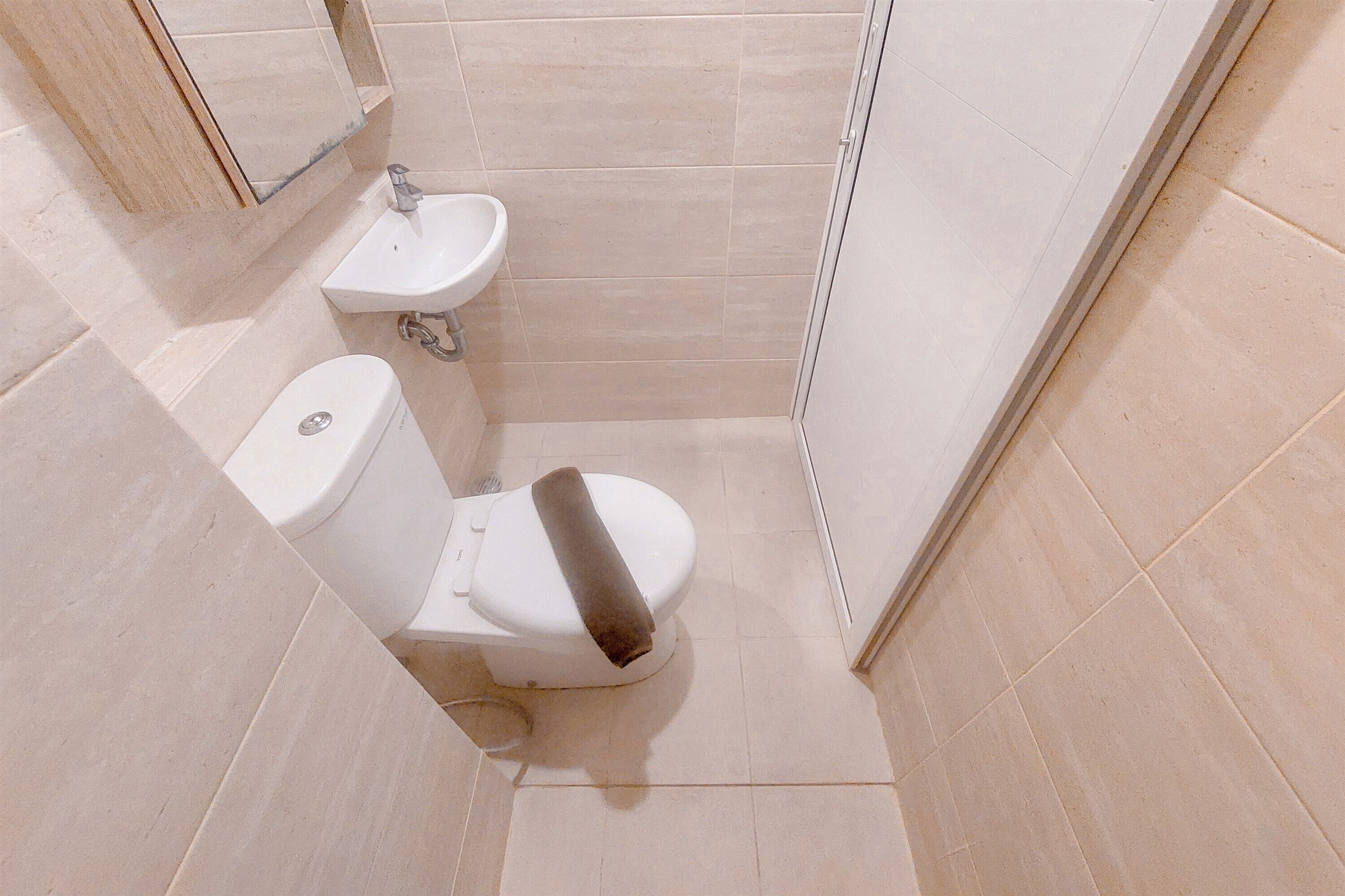 Une petite salle de bain moderne comprenant des toilettes, un lavabo et un espace douche.
