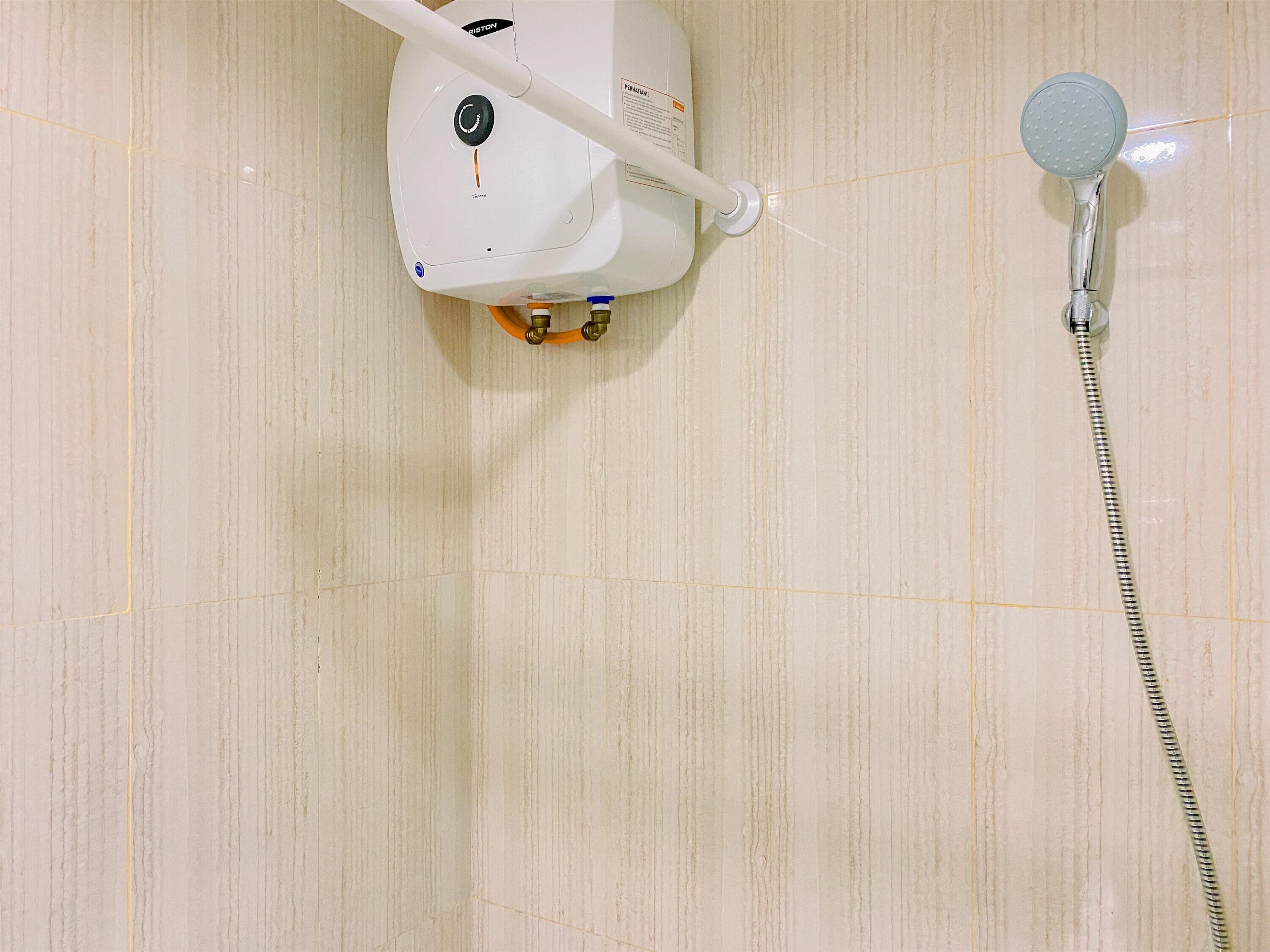 A bathroom with a white shower unit and a handheld showerhead.