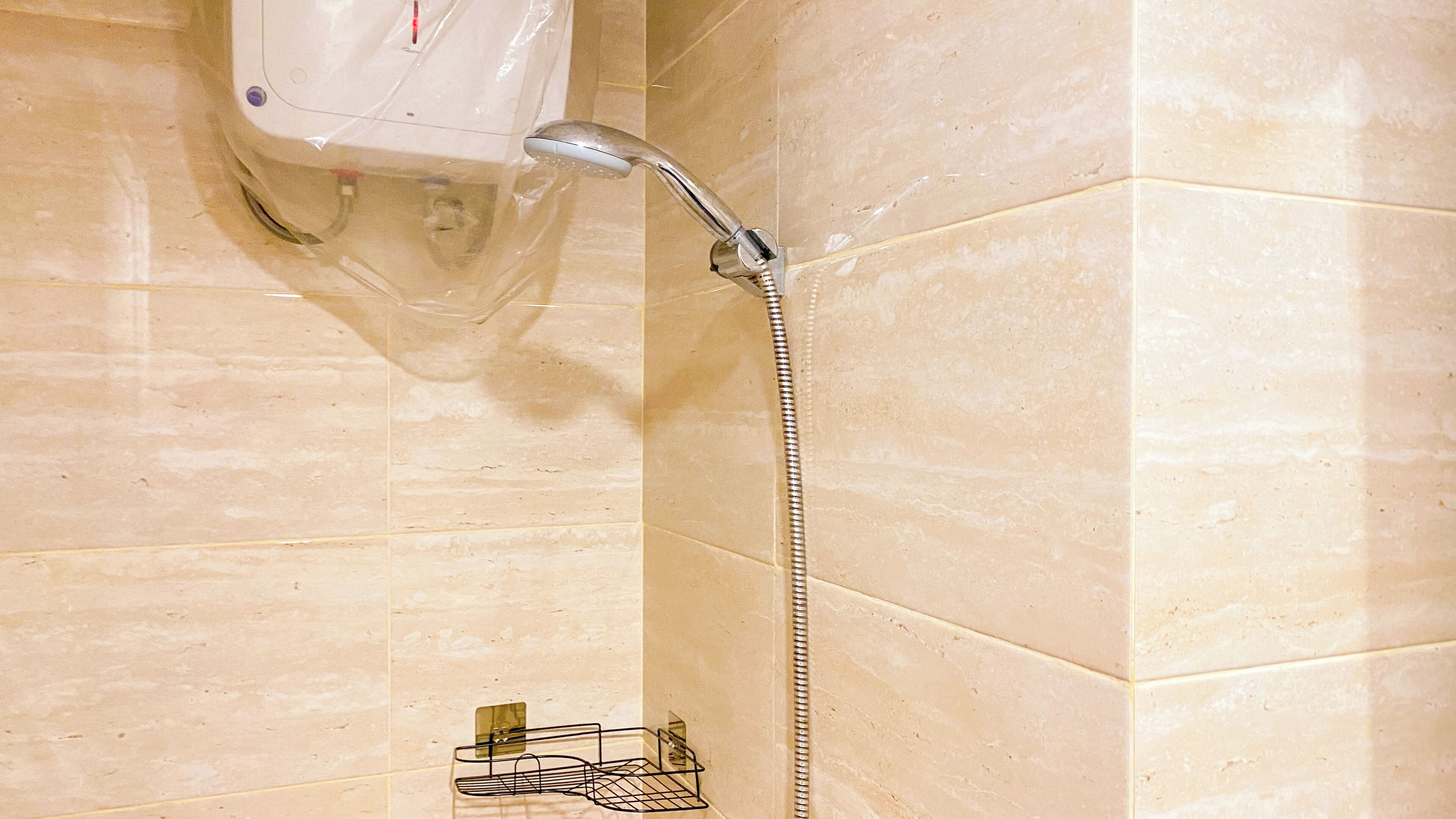 A shower with a handheld showerhead and a wall-mounted faucet.