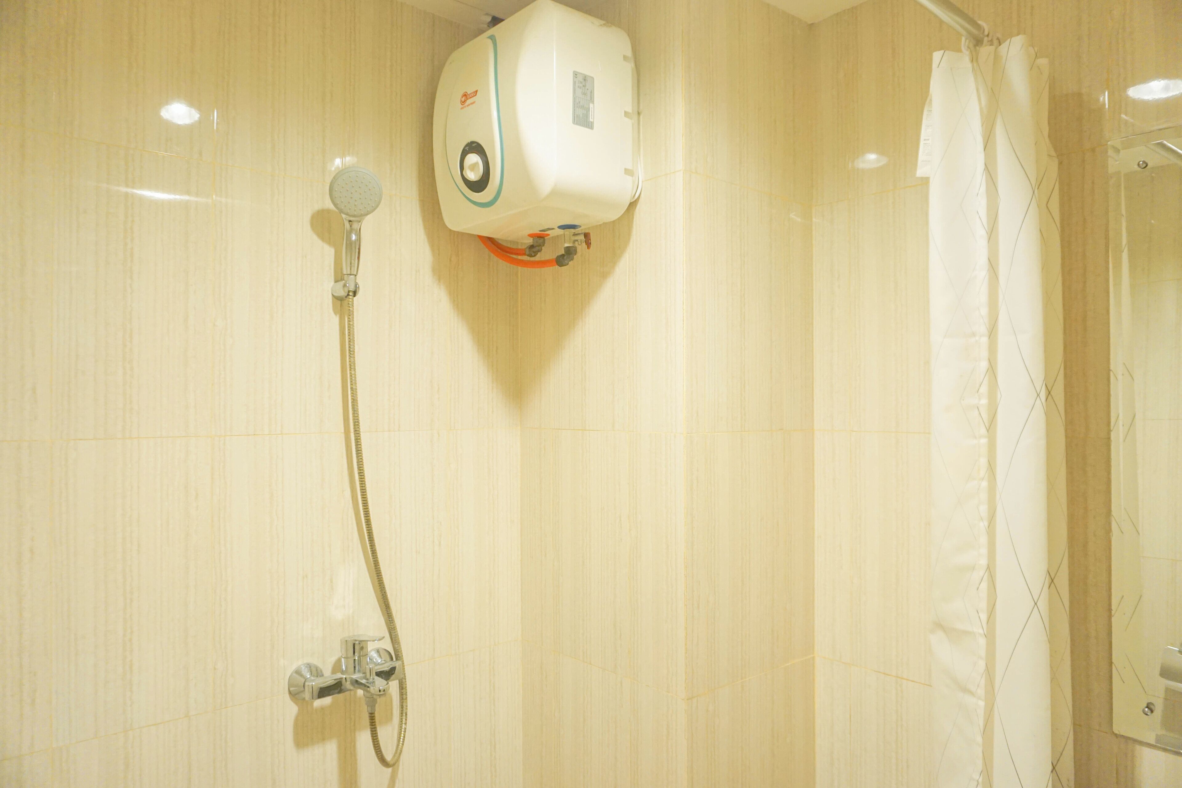 A bathroom with a shower, a toilet, and a mirror.