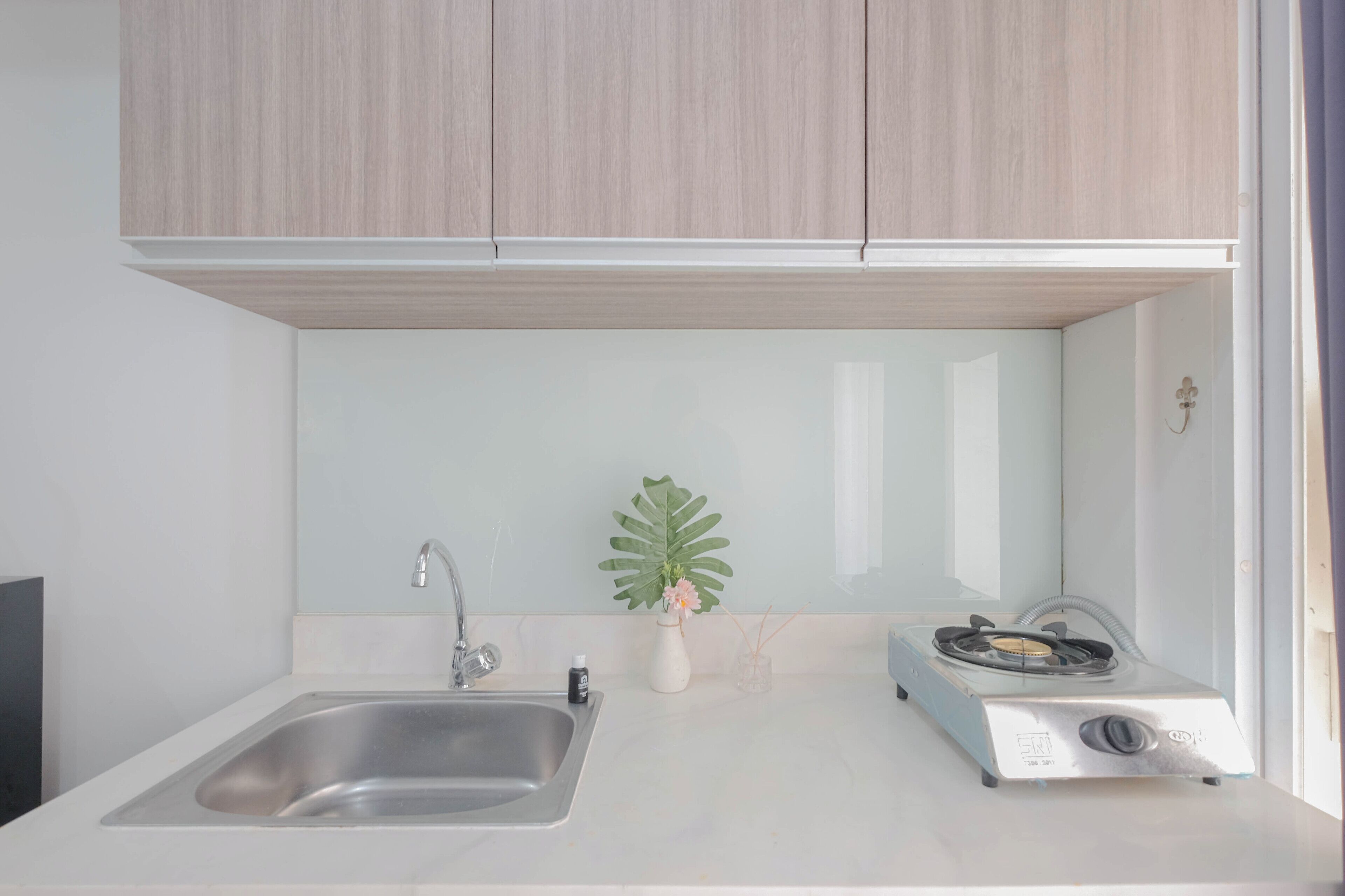 A modern kitchen with a stainless steel sink, a gas stove, and wooden cabinets.
