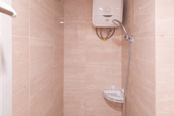 A shower area with a handheld showerhead, a wall-mounted control panel, and a white shower caddy.